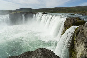 Photo art by Jürgen Gross: serene shot of Godafoss with mist and rocks