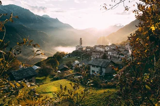 Romantisches Bergdorf in der Schweiz bei Sonnenuntergang mit sanften Farben.