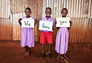 Photo art by Victoria Knobloch: smiling children from Uganda in a school setting.