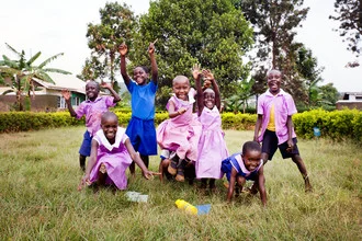 Photo art by Victoria Knobloch: happy children playing in front of a school in Uganda.