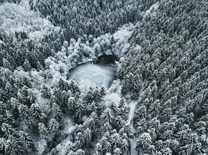 Beautiful frozen lake surrounded by snow-covered forests in the Erzgebirge region