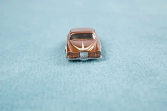 Photo art of a car on a carpet, featuring soft blue and beige tones.