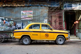 Fotokunst von Miro May: gelbes Taxi auf einer Straße in Kolkata