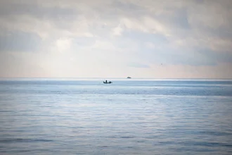 Photo by Katharina Stöcker: serene coastal landscape featuring a fishing boat