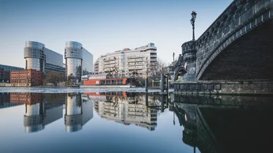 Berlin Spreebogen in winter: calm water surface with snow and ice