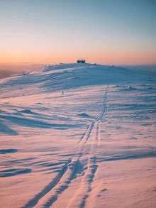 Charming house on a hill in snowy Sweden during sunrise.