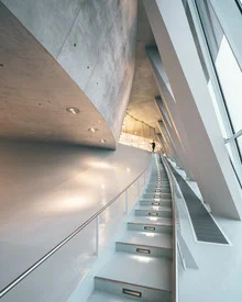Minimalist staircase photo in a museum with leading lines and warm lighting.