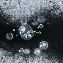 Photo art by Ezra Portent: frozen bubbles on an ice surface