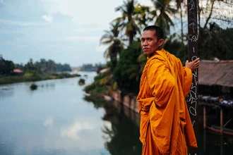 Buddhistischer Mönch blickt nachdenklich auf den Mekong in Laos.