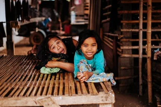 Fotokunst von Jim Delcid: Mutter und Tochter in Tad Lo, Laos, friedliche Momentaufnahme.