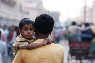 Photo art by Simon Bode: father and son in a busy street in Delhi