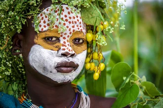 Close-up of a Suri woman with body painting and a gentle smile