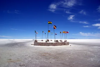 Fotokunst von Martin Erichsen: bunte Fahnen wehen über der salzweißen Landschaft in Bolivien.