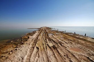 Photo art: Gentle road through Namibia's landscape with a water view in the background