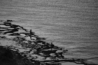 Fotokunst von Martin Erichsen: Fischer am Meer während eines friedlichen Sonnenuntergangs