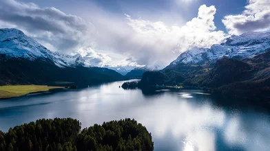 Photo art by Rémi Peschet: tranquil lake with mountains and clouds in the background
