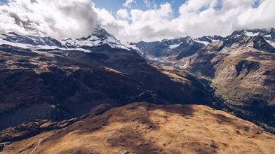 Aerial view of the Matterhorn in Switzerland, surrounded by clouds and mountains.