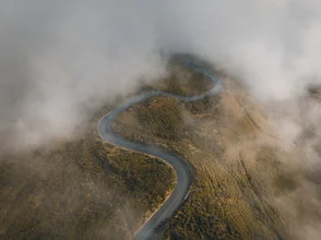 Beautiful landscape in Madeira, shrouded in fog, with a calm road in the foreground.