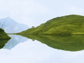 Photo art by Timo Maier: calm lake with cabin and mountain reflection in the Allgäu