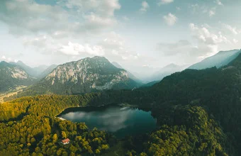 Photo art by Rémi Peschet: tranquil lost lake surrounded by mountains.