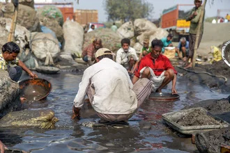 Fotografie eines Goldsuchers in Kolkata, der mit Wasser und goldenen Farbtönen spielt.