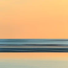 Fotokunst von Holger Nimtz: sanfter Sonnenaufgang über der Nordsee mit ruhigen Wellen.