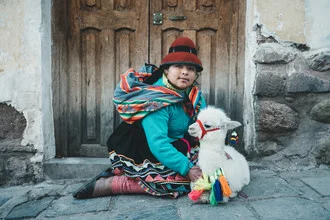 Peruvian girl with an alpaca, cheerful and colorful in traditional clothing