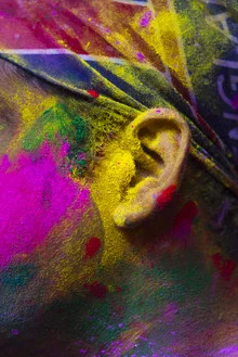 Colorful festival scene with joyful people being splashed with colors.