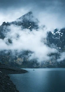 Photo art: lonely fisherman by a tranquil mountain lake in the Alps