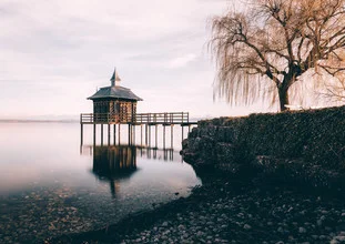 Photo art by Niels Oberson: tranquil lake reflecting trees and a pavilion.
