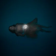 Photo art by Rova Fineart - Simone Betz: a woman swims beneath the moon in space.