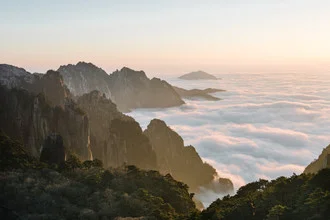 Beautiful mountain landscape in Huang Shan, China, with soft clouds and warm colors.