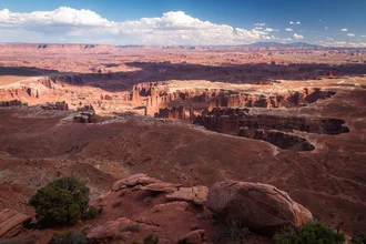 Expansive canyon landscape with gentle hills and blue sky