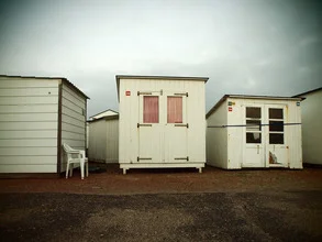 Beach houses at the coast: calm scene with wooden huts in autumn light.