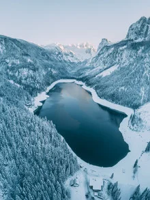 Snow-covered lake in the Alps, tranquil winter landscape with soft colors.