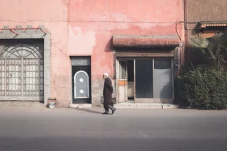 Farbenfrohe Straßenaufnahme in Marrakesch mit einem Mann, der durch die Stadt läuft.