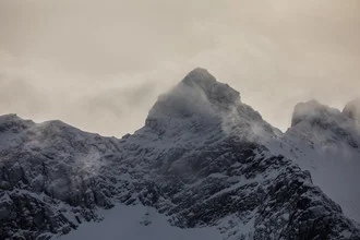 Schneebedeckter Berggipfel in Norwegen, umgeben von klarem, blauem Himmel