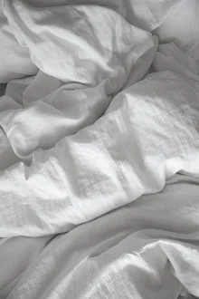Gemütliches Bett mit Decken und Kissen für einen entspannten Tag im Schlafzimmer