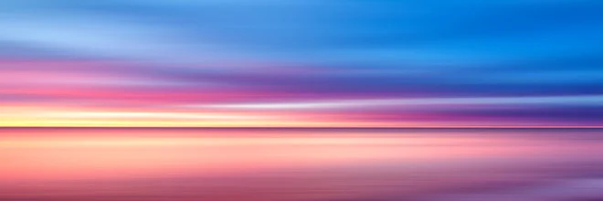 Wall art depicting an abstract sunset in warm yellow and purple hues