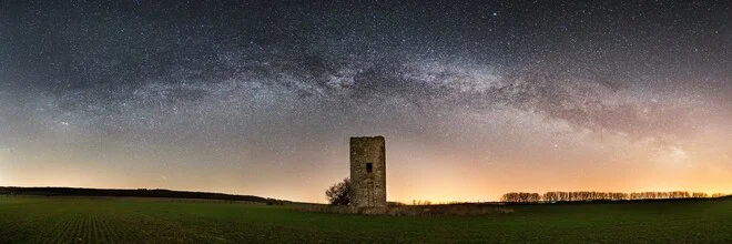 Milchstraßen-Panorama über einem alten Wachturm im Harz, ruhige Nacht mit vielen Sternen.