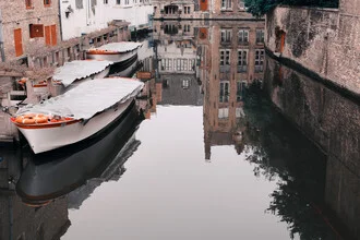 Canal in Bruges with boats and reflections in the water