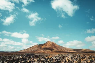 Photo art by Philipp Awounou: hilly landscape beneath gentle clouds.