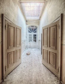 Abandoned hallway with faded colors and an open door in the background.