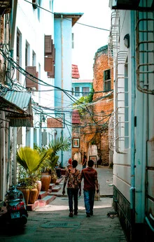 Colorful street in Tanzania with pedestrians in a lively atmosphere.