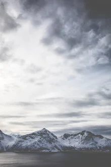 Photo art by Sebastian Worm: icy mountains beneath a clear sky in Norway