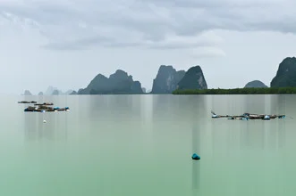 Ruhevolle Szene im Phang-Nga-Bay mit Fischerbooten und sanften Wolken.