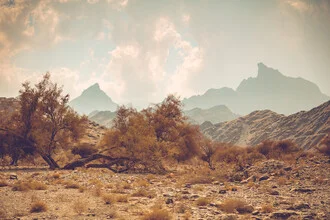 Photo art by Franz Sussbauer: dry valley with mountain ridge and clouds in Oman