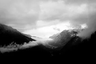Clouds above a valley with gentle hills and a calm sky.