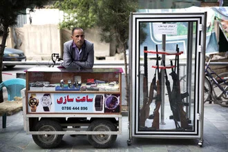 Photo art by Theresa Breuer: vendor with weapons and watches on a busy street in Kabul