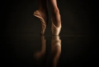 Photo art by Klaus Wegele: graceful feet in ballet shoes on a reflective surface.